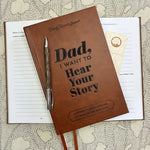 Brown leather journal with 'Dad, I Want to Hear Your Story' text on a textured surface